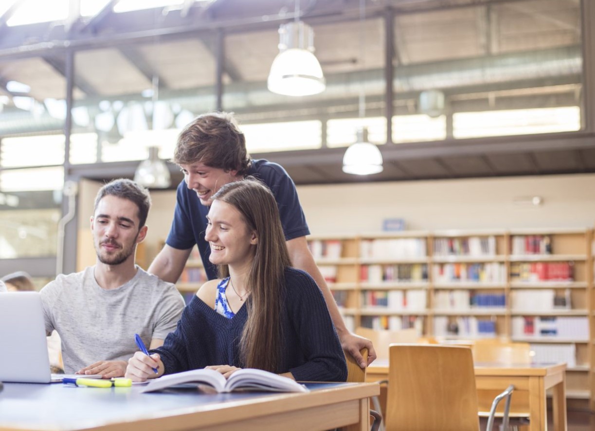 Tres estudiantes trabajando con ordenado